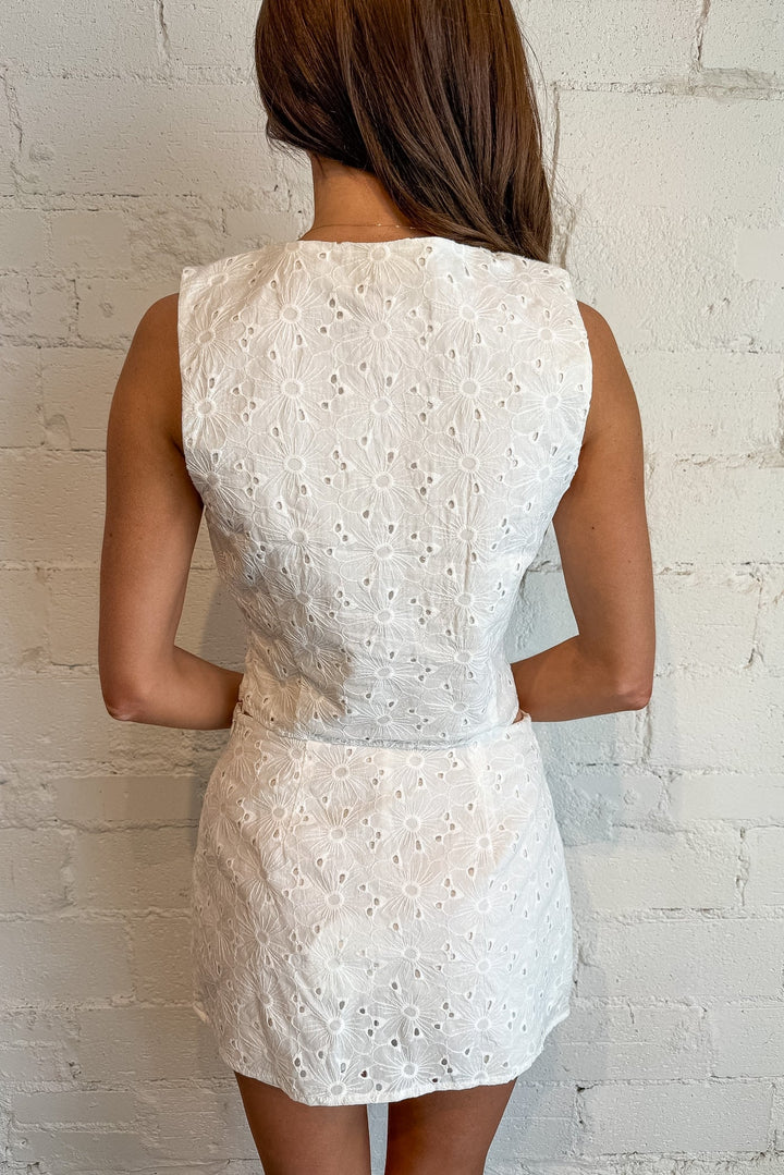 Woman wearing a white lace dress against a light brick wall, Sets, Spring Sets, Spring and Summer Styles, Mini Skirt, Bottoms, Easter Outfit, Adeline Boutique, Dallas Boutique