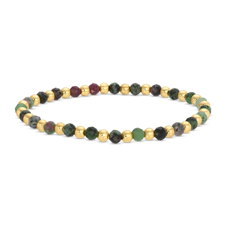 A beaded stretch bracelet featuring alternating polished gold-tone metal beads and faceted gemstone beads in shades of green, dark gray, and deep burgundy, displayed on a clean white background.