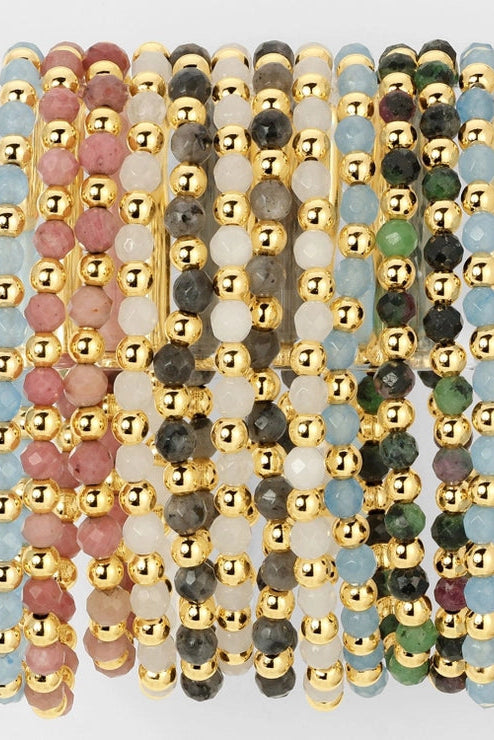 Set of beaded bracelets with gold accents on a light gray background